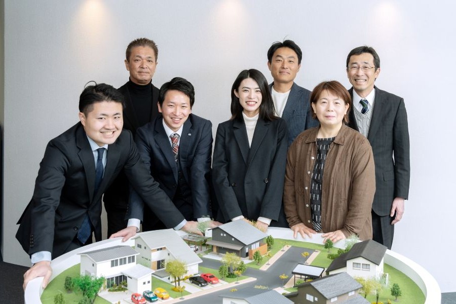 住宅地のジオラマを前にした不動産営業マン