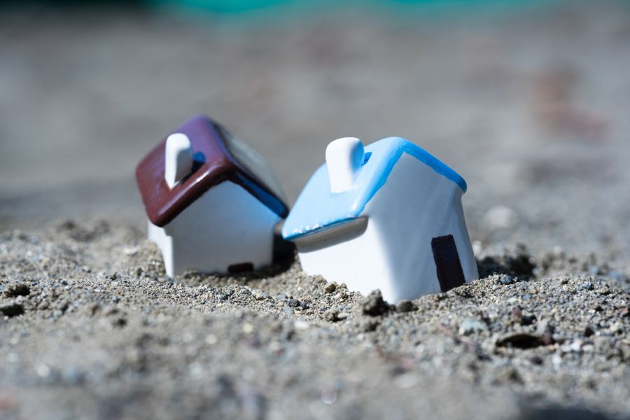 家のおもちゃが土に埋まって傾いている液状化のイメージ